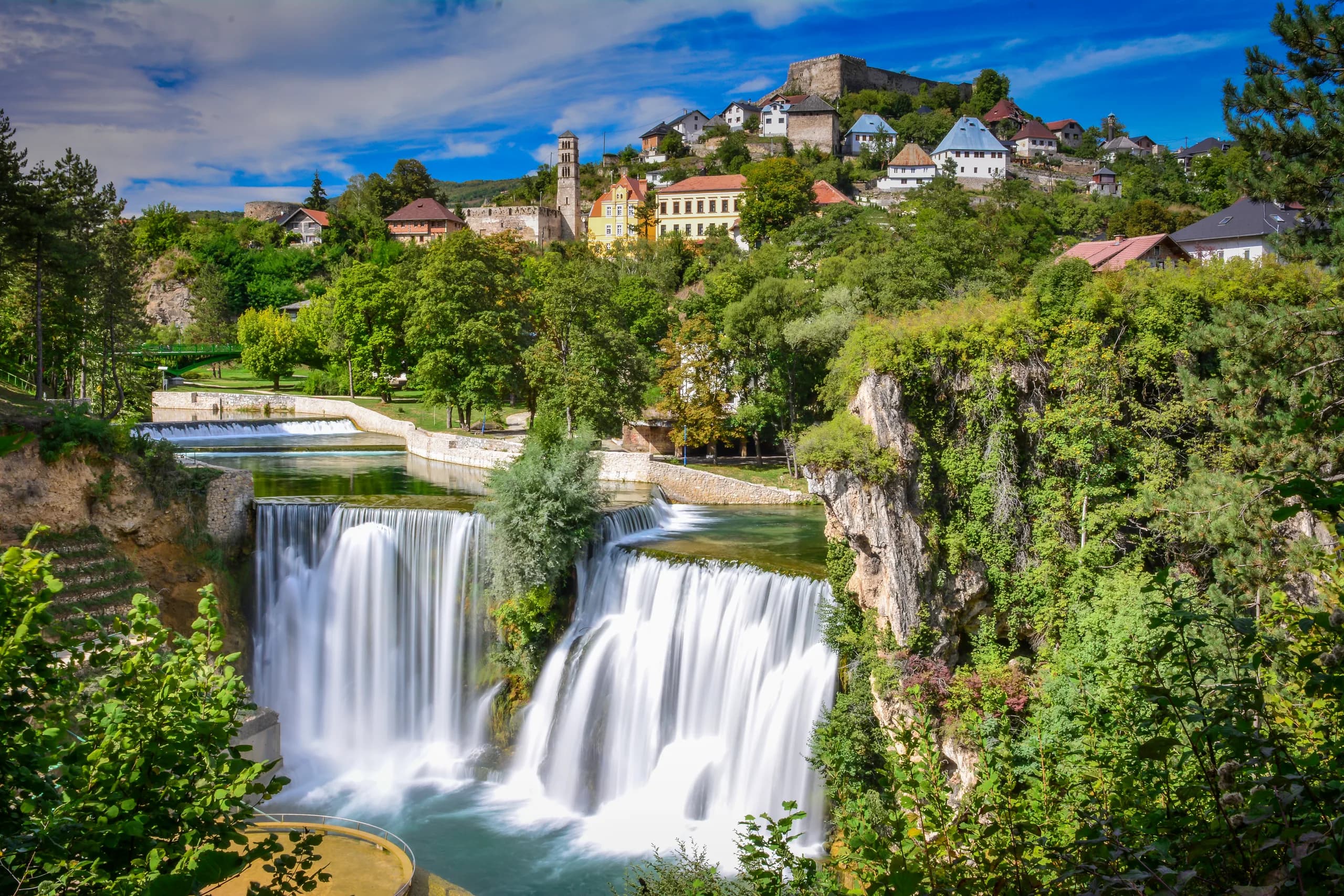 Der Pliva-Wasserfall in Jajce, darüber die Altstadt mit einem Glockenturm und der Festung