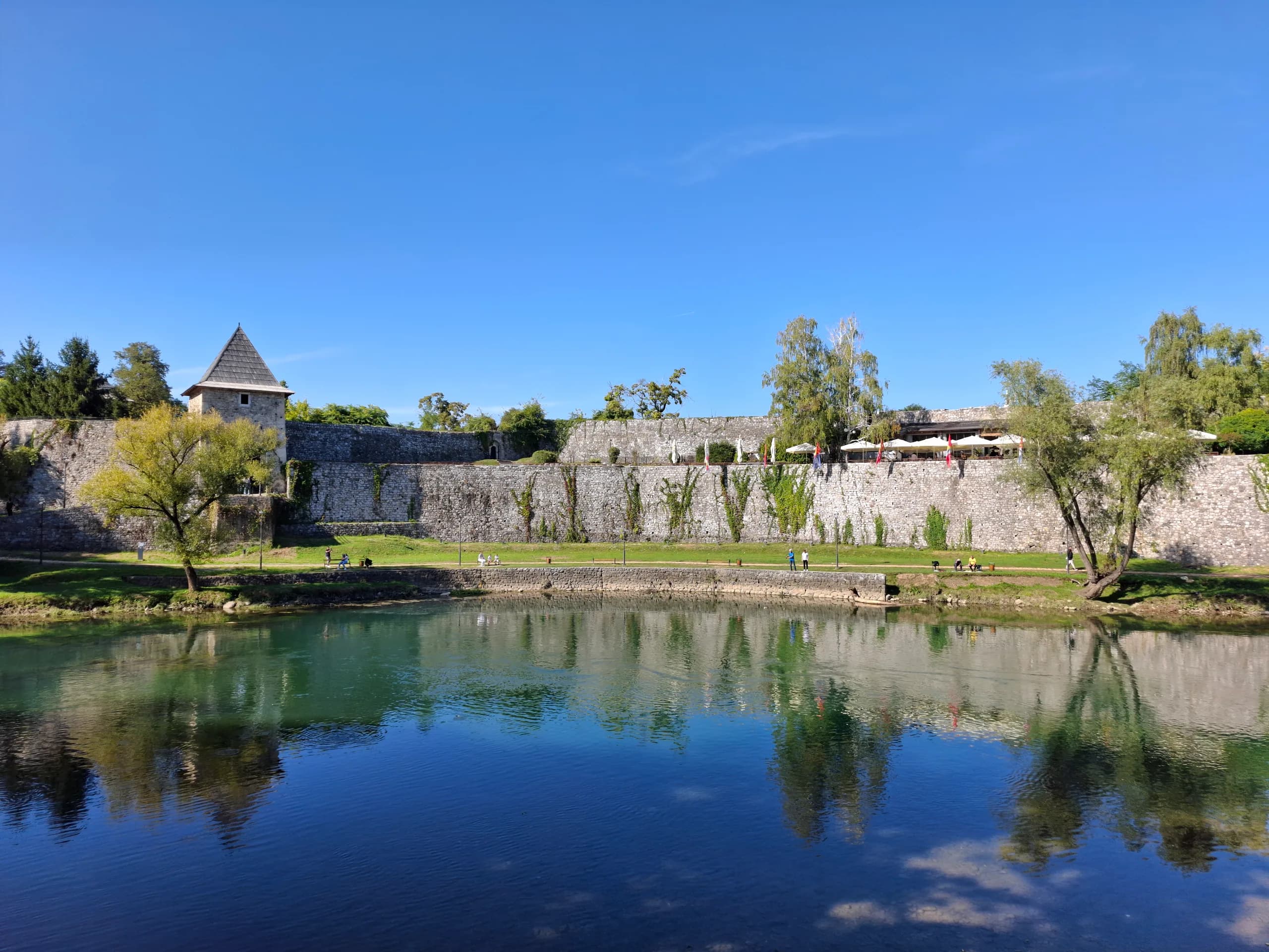 Die Mauern der Festung Kastel in Banja Luka mit einem Turm, gespiegelt im Wasser des Vrbas